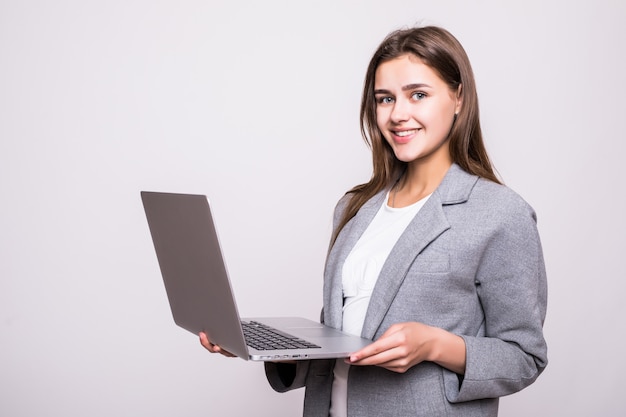 흰색 배경에 고립 된 노트북에서 일하는 젊은 여자