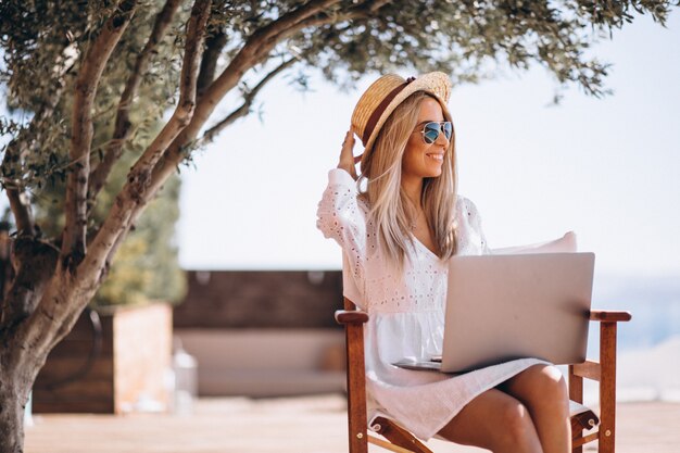 Молодая женщина работает на ноутбуке в отпуске