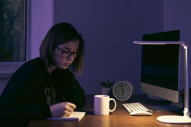 Una giovane donna che lavora di notte sul posto di lavoro