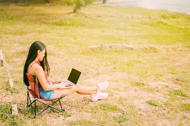 무료 사진 야외에서 노트북에서 일하는 젊은 여자