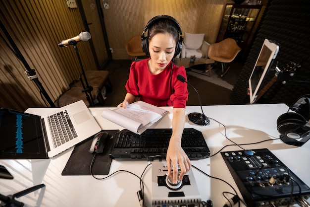 Free photo young woman working at radio with professional equipment