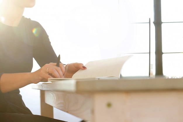 Giovane donna che lavora con il computer portatile e l'agenda