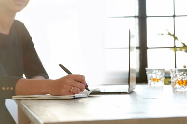 Young woman working with laptop and agenda