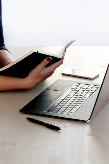 Free photo young woman working with laptop and agenda