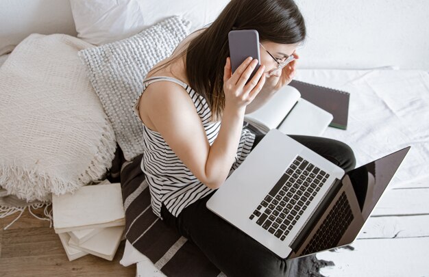 A young woman works remotely at a computer at home. Freelancer and work on the Internet.