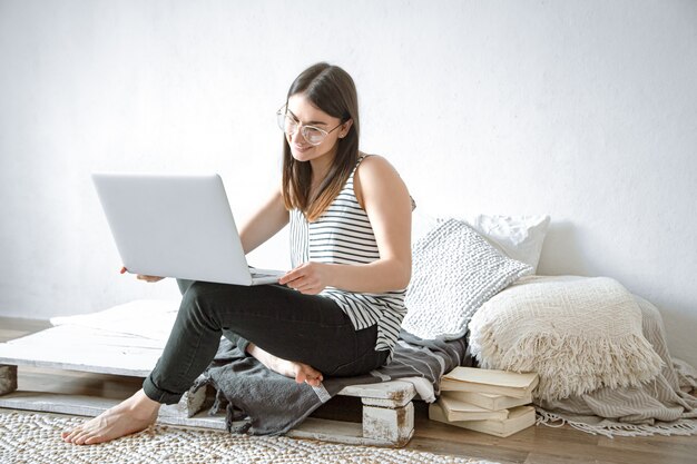 A young woman works remotely at a computer at home. Freelancer and work on the Internet.