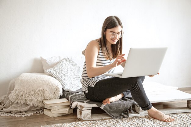 young woman works remotely at a computer at home.