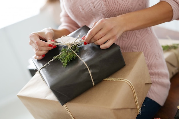 Free photo young woman wrapping presents