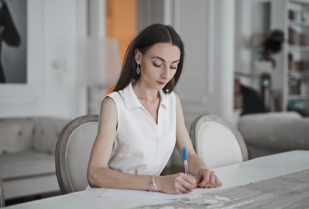 young woman writes on paper at home