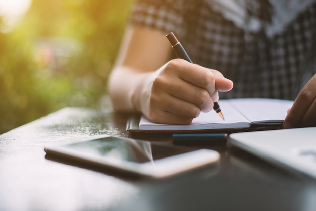 Young woman writing on a notebook