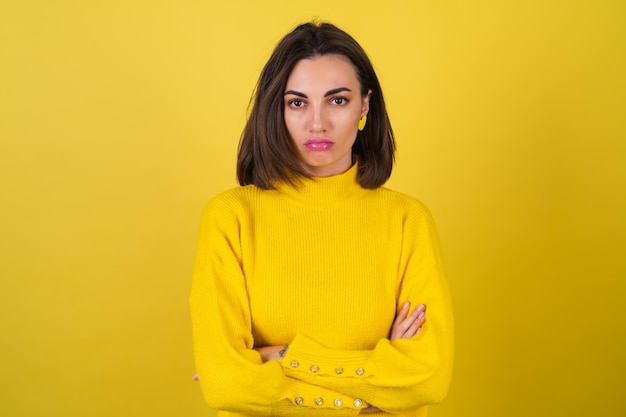 Free photo young woman in a yellow cozy sweater   with bright pink lip gloss is upset, offended, unhappy