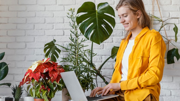 Young woman in yellow shirt gardening at home