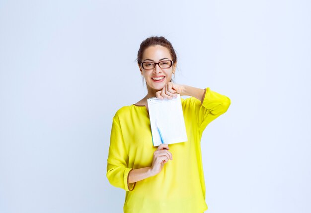 Young woman in yellow shirt showing the quiz results and the mistakes on it