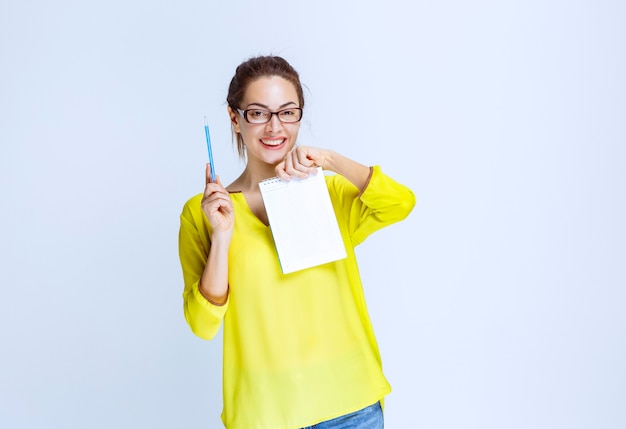 Young woman in yellow shirt showing the quiz results and the mistakes on it