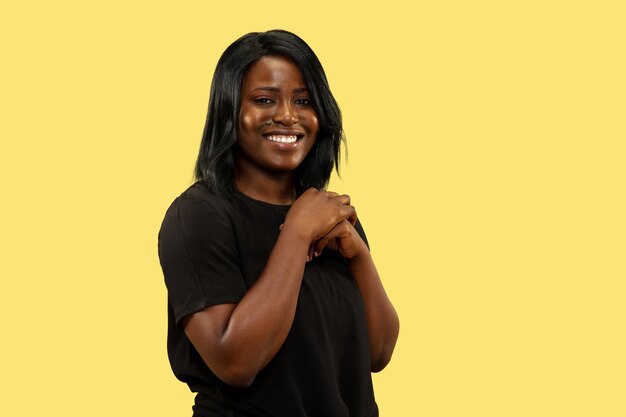 Young woman on yellow studio