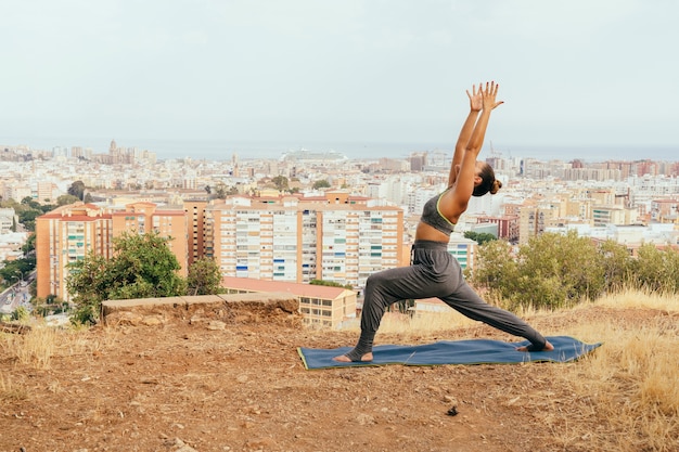 Young woman at yoga and the city behind