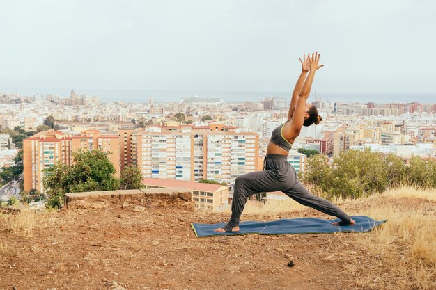 Young woman at yoga and the city behind