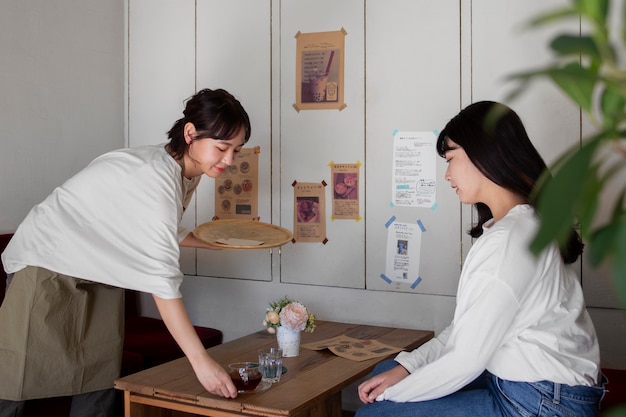 Free photo young women arranging their cake shop