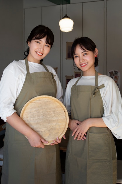 Free photo young women arranging their cake shop