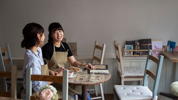 Free photo young women arranging their cake shop