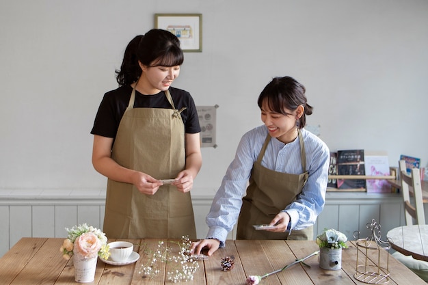 Free photo young women arranging their cake shop