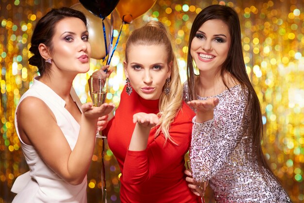 Young women blowing kisses, celebrating the new year