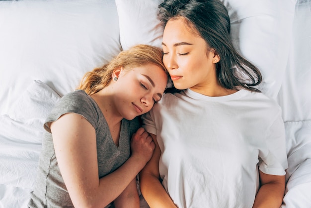 Young women cuddling sleeping in bed