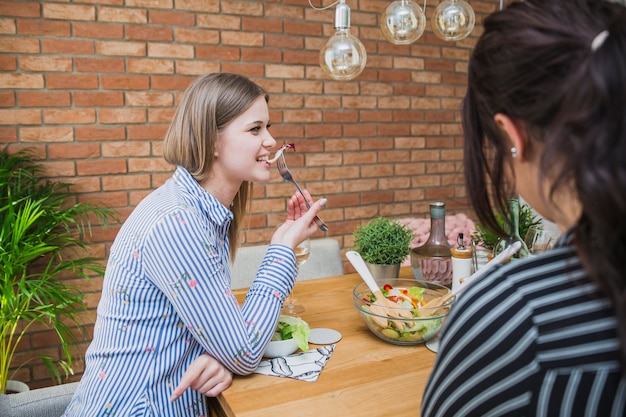 テーブルで食べる若い女性