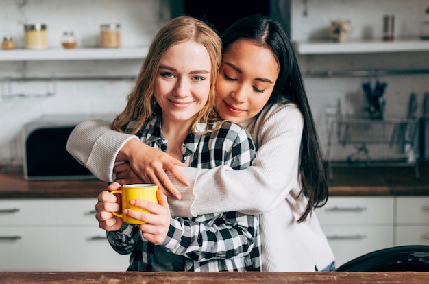 Young women embracing in kitchen