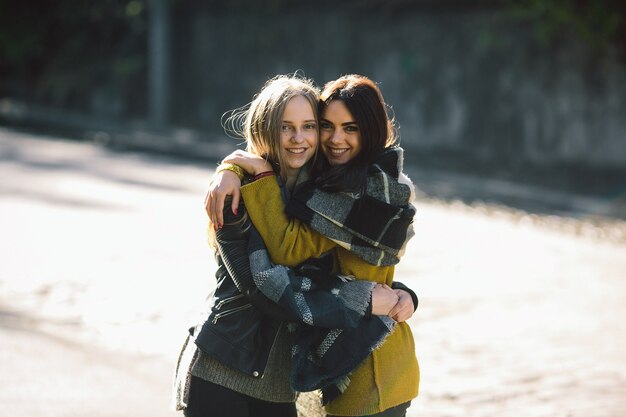 Молодые женщины, обнимающие друг друга