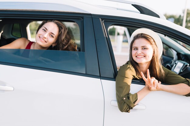 Young women hanging out of car window