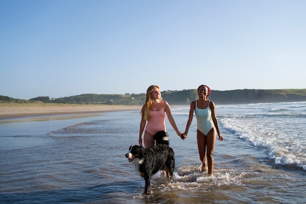 해변에서 강아지와 즐거운 시간을 보내는 젊은 여성