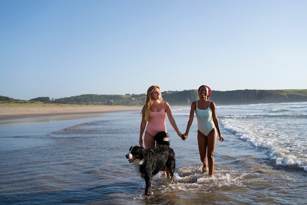 ビーチで犬を楽しんでいる若い女性