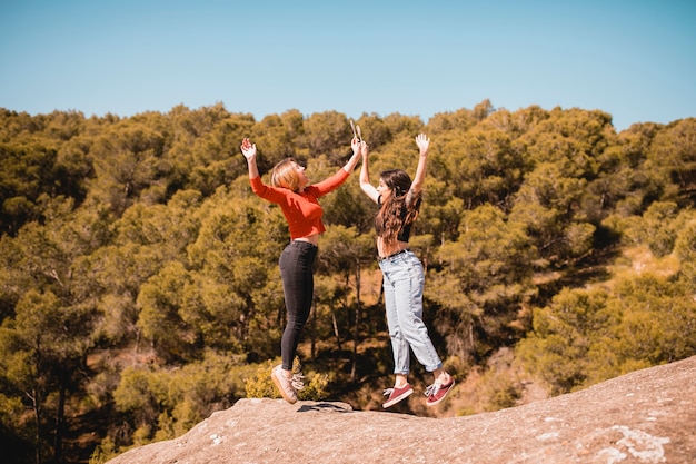 Young women jumping on cliff