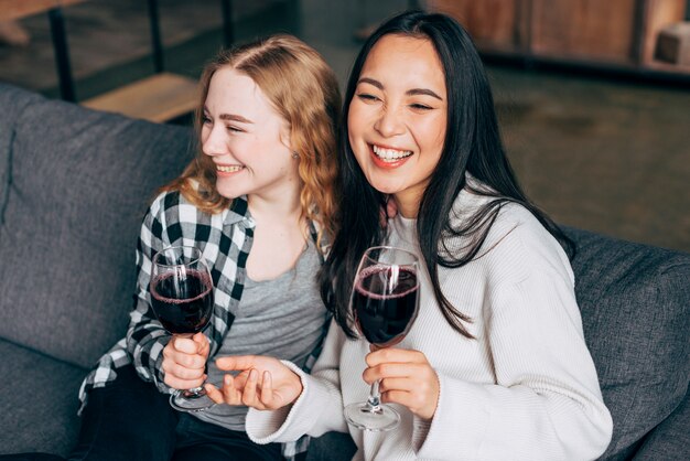 笑いとワインを飲む若い女性