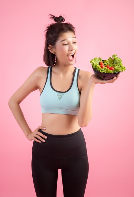 若い女性はピンクの野菜を食べるのが好きです。