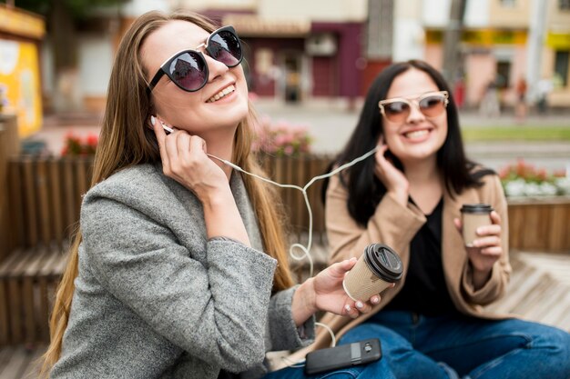 Young women listening to music through earphones