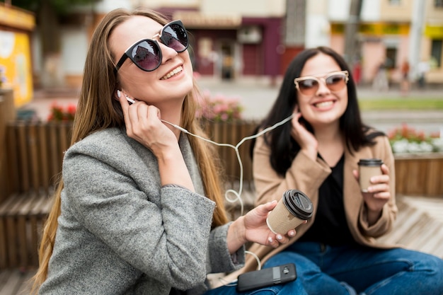 Молодые женщины слушают музыку через наушники