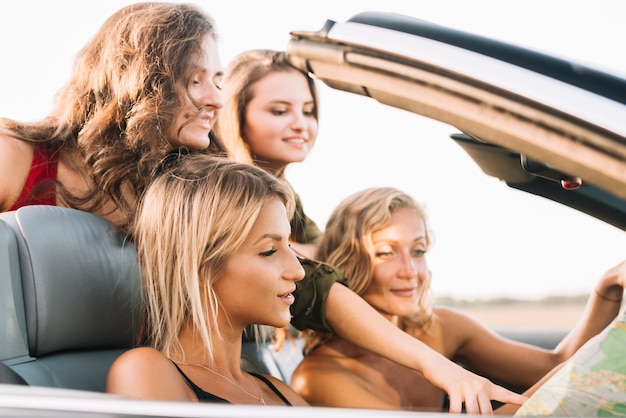 Young women looking at map in car