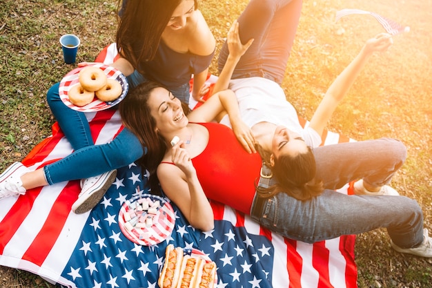Молодые женщины, лежащие на американском флаге
