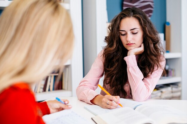 Young women making notes at table