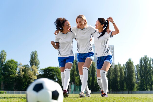 サッカーチームで遊ぶ若い女性