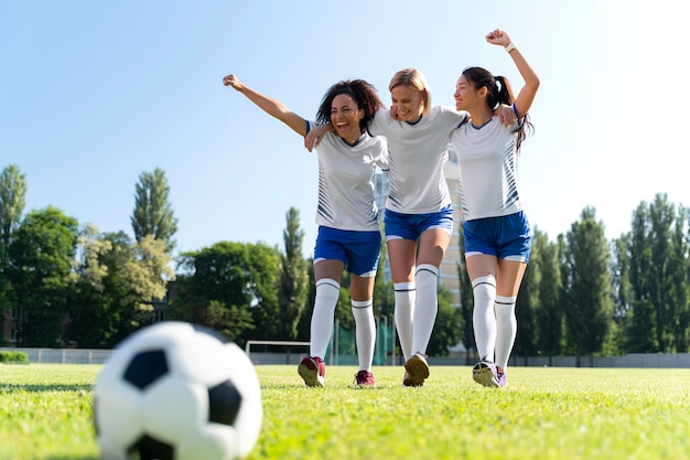 サッカーチームで遊ぶ若い女性