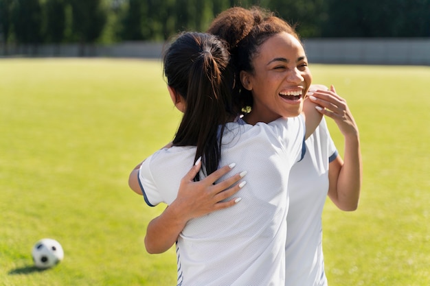 サッカーチームで遊ぶ若い女性