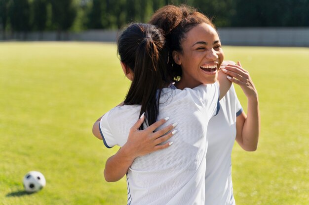 サッカーチームで遊ぶ若い女性