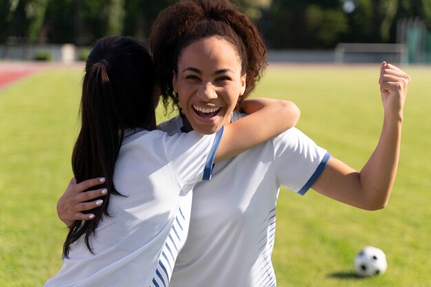 サッカーチームで遊ぶ若い女性