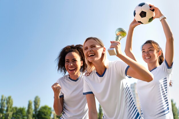 サッカーチームで遊ぶ若い女性