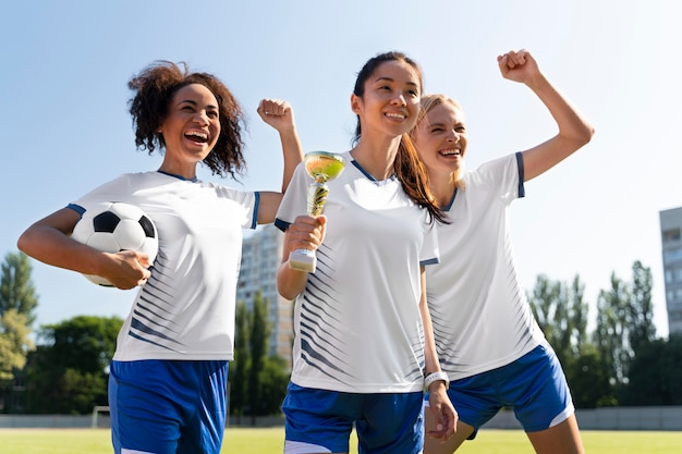 サッカーチームで遊ぶ若い女性