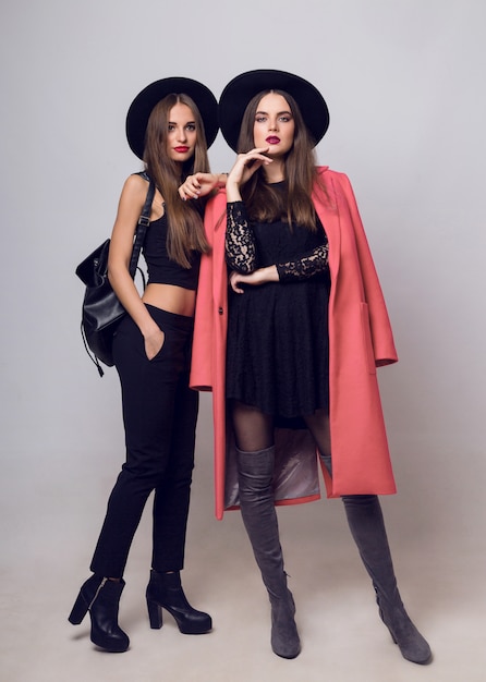 Young women posing and wearing stylish black hats