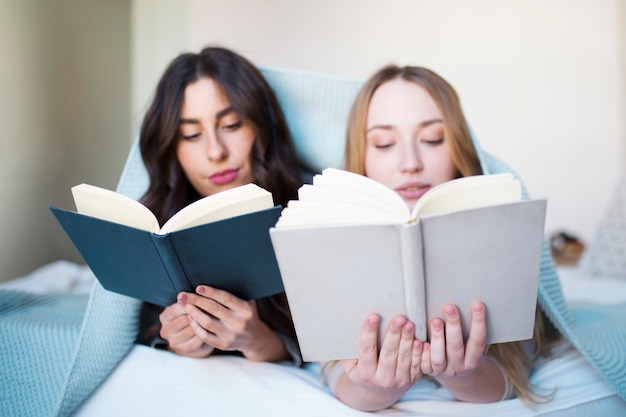 침대에서 독서하는 젊은 여성